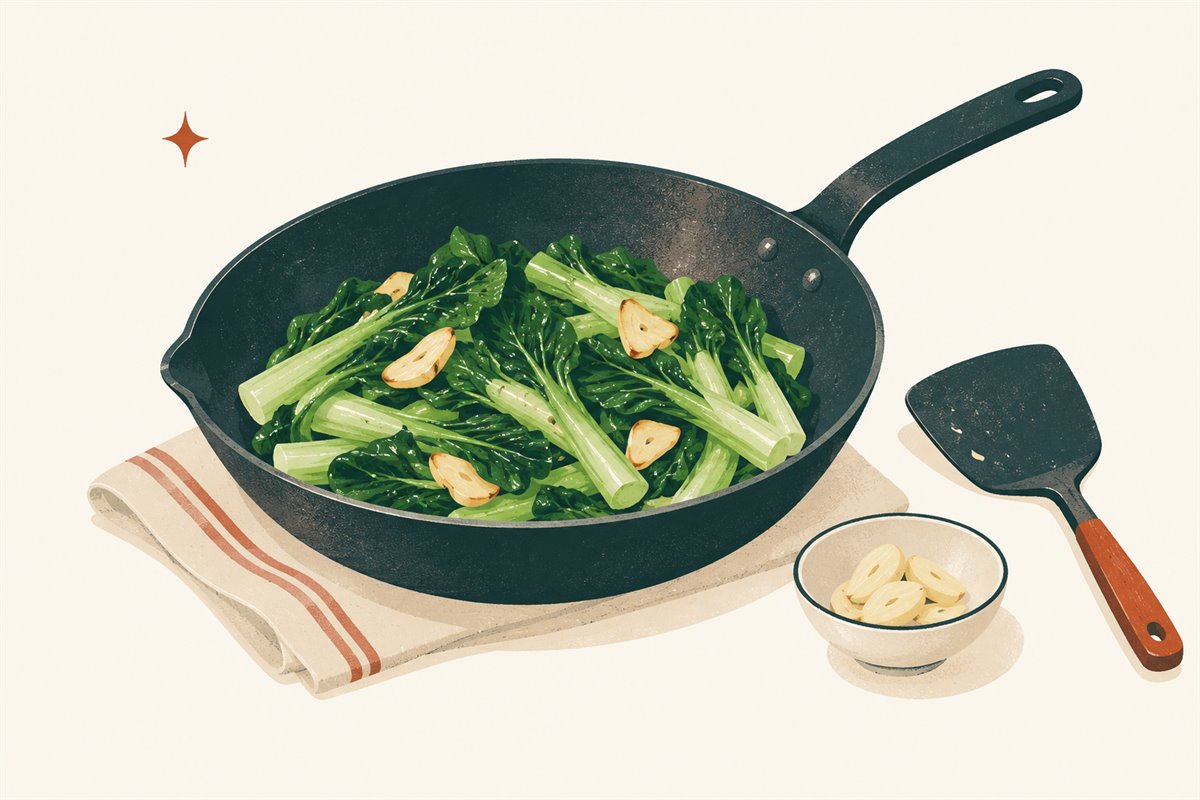Garlic choy sum stir-fry in a skillet with a broad cooking spatula